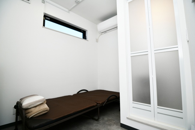 スライド画像: 仮眠室 - 事務所内に設置された仮眠室です。ベットとシャワールームが設置されています。